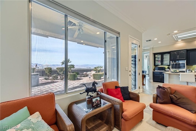 tiled living room featuring crown molding and ceiling fan