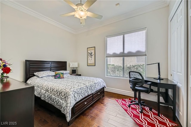 bedroom featuring crown molding, ceiling fan, dark hardwood / wood-style flooring, and a closet