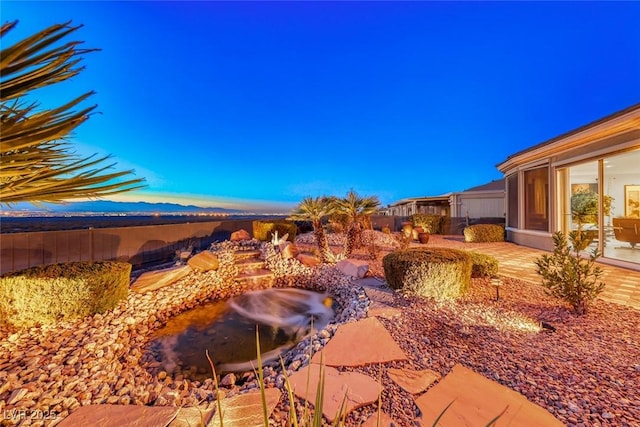 yard at dusk featuring a patio area