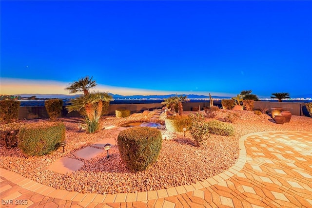 yard at dusk featuring a patio area