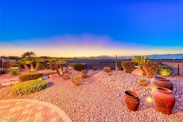 yard at dusk with a mountain view and a patio area