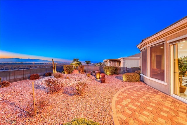 yard at dusk with a patio area