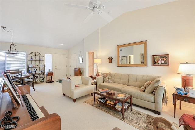 carpeted living room with ceiling fan with notable chandelier and vaulted ceiling