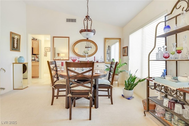 carpeted dining room with lofted ceiling