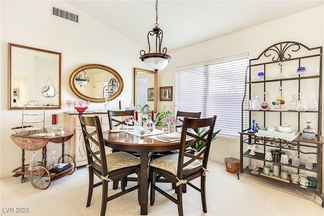 dining space with carpet flooring, plenty of natural light, and lofted ceiling