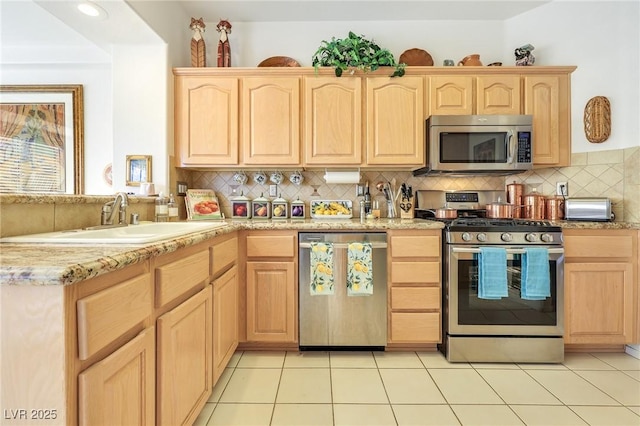 kitchen featuring light brown cabinets, light tile patterned floors, stainless steel appliances, and sink