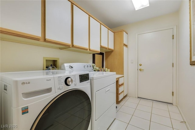 clothes washing area with washer and dryer, light tile patterned floors, and cabinets