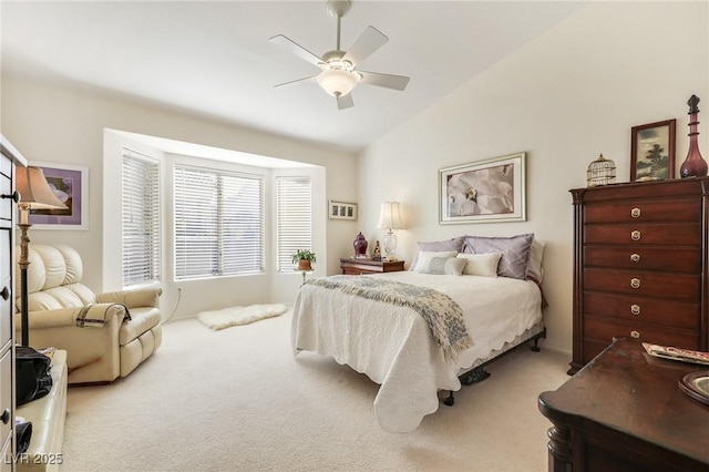 bedroom featuring ceiling fan, light colored carpet, and lofted ceiling