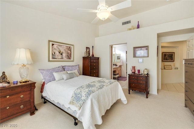 bedroom featuring ensuite bathroom, ceiling fan, and light colored carpet