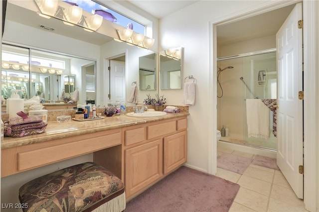 bathroom with tile patterned flooring, vanity, and walk in shower