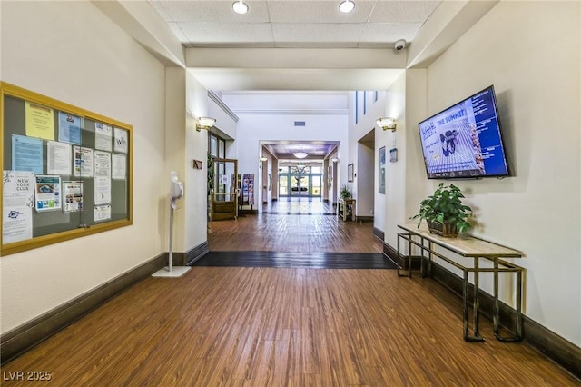 hallway featuring a paneled ceiling and dark wood-type flooring