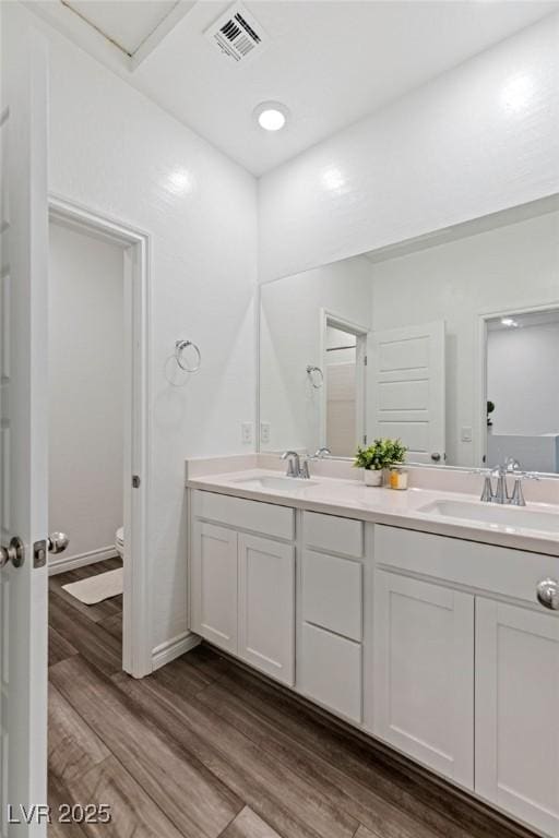 bathroom featuring vanity, wood-type flooring, and toilet