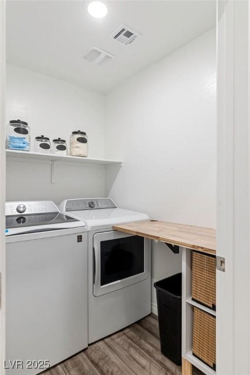 laundry room featuring hardwood / wood-style floors and washing machine and dryer