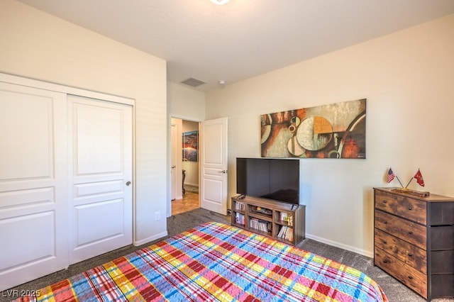 bedroom with dark carpet and a closet