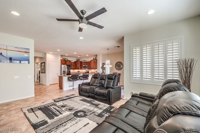 living room featuring sink, ceiling fan, and light tile patterned flooring