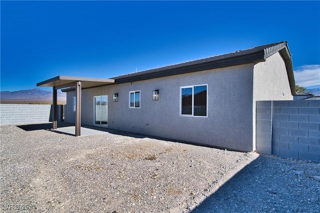 rear view of house with a mountain view and a patio