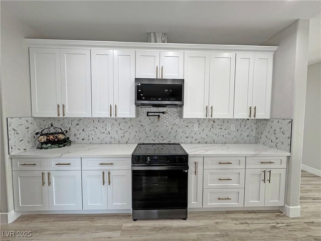 kitchen with backsplash, light stone counters, white cabinets, and appliances with stainless steel finishes