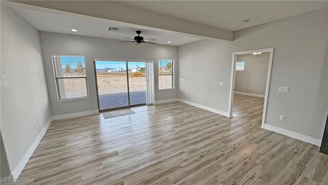 spare room with ceiling fan, a healthy amount of sunlight, and light hardwood / wood-style flooring