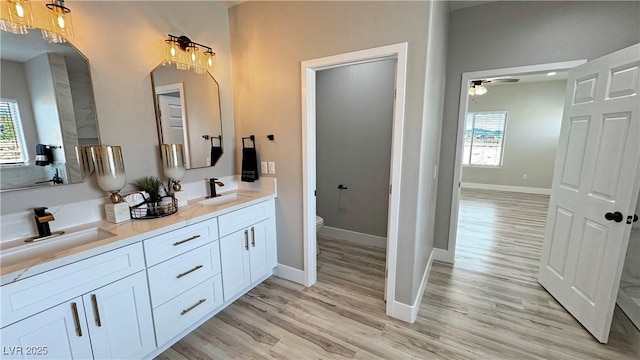 bathroom featuring vanity, hardwood / wood-style flooring, toilet, and ceiling fan