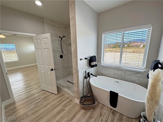 bathroom with independent shower and bath and wood-type flooring