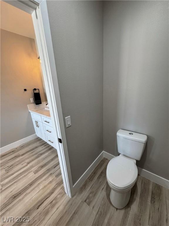 bathroom featuring vanity, wood-type flooring, and toilet