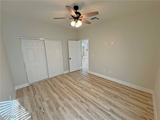 unfurnished bedroom featuring ceiling fan, light hardwood / wood-style floors, and a closet