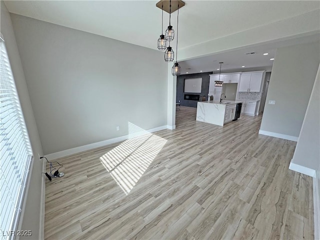 unfurnished living room with light hardwood / wood-style floors and sink