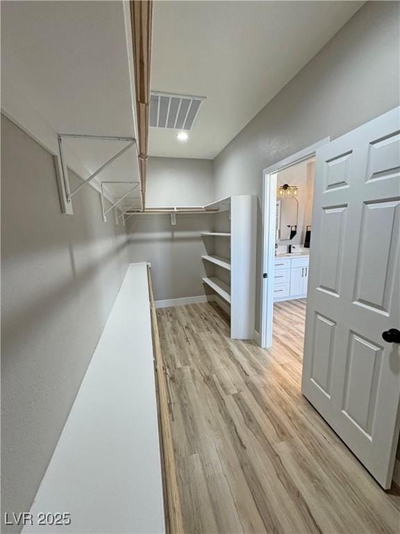 spacious closet with light hardwood / wood-style flooring