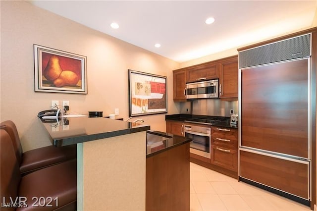 kitchen with kitchen peninsula, a breakfast bar, and appliances with stainless steel finishes