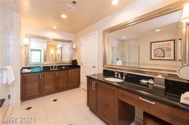 bathroom featuring vanity, tile patterned floors, and a shower with shower door