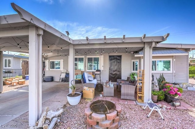 exterior space featuring a patio area and an outdoor living space with a fire pit