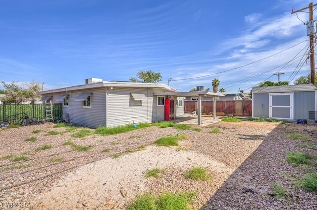 back of house featuring a storage shed