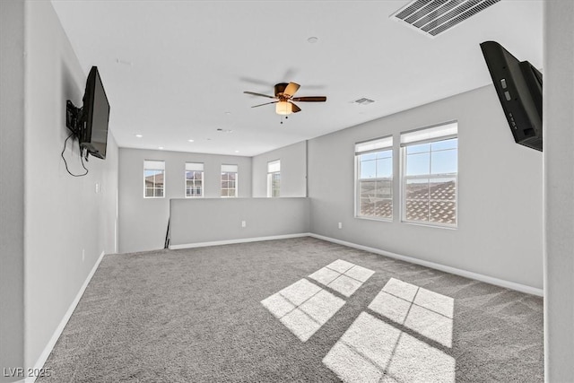 unfurnished room featuring a wealth of natural light, ceiling fan, and light colored carpet