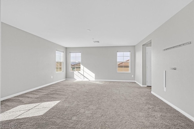 unfurnished living room featuring plenty of natural light and carpet