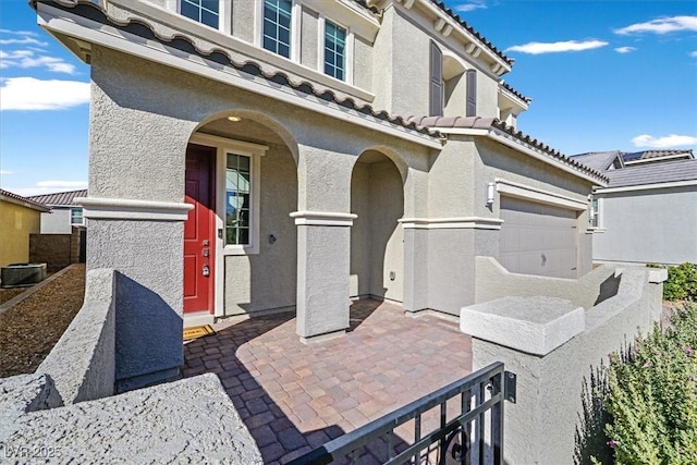 view of patio featuring a garage and central AC unit