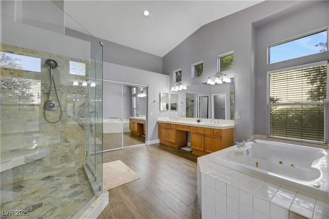 bathroom featuring vanity, separate shower and tub, plenty of natural light, and lofted ceiling