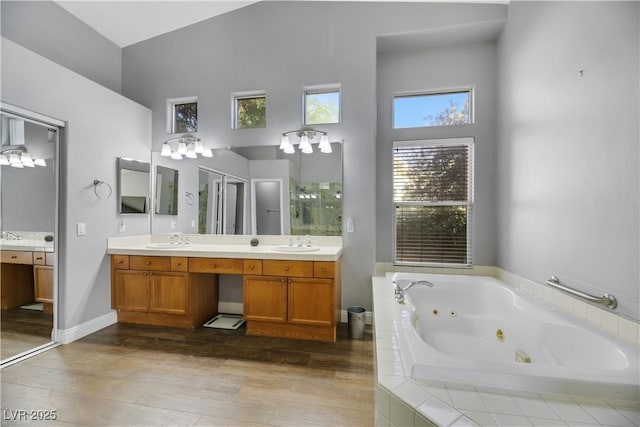 bathroom featuring tiled tub and vanity