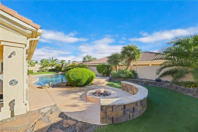 view of patio with a fenced in pool and a fire pit