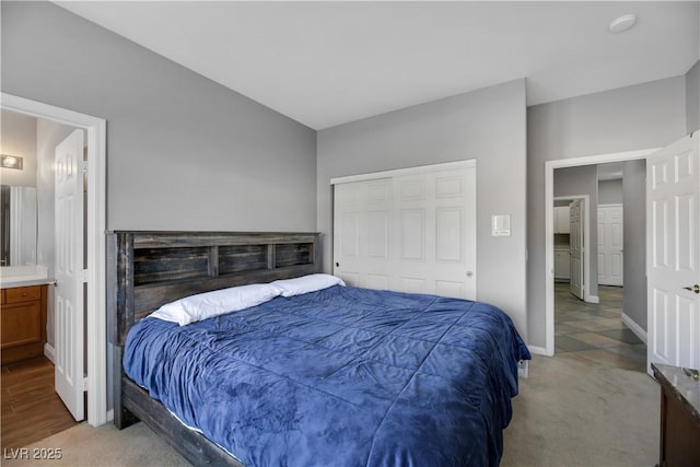 bedroom featuring carpet, a closet, and ensuite bath