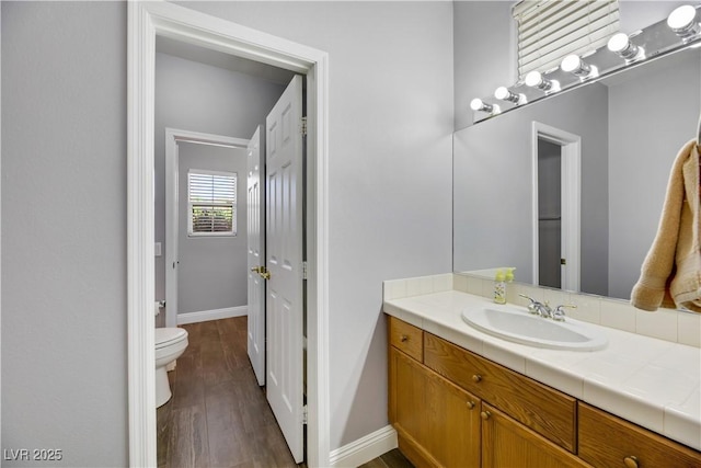 bathroom featuring vanity, hardwood / wood-style flooring, and toilet