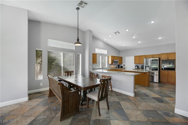 dining space featuring high vaulted ceiling