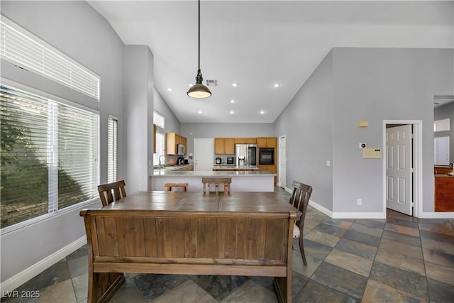 dining space featuring high vaulted ceiling and sink