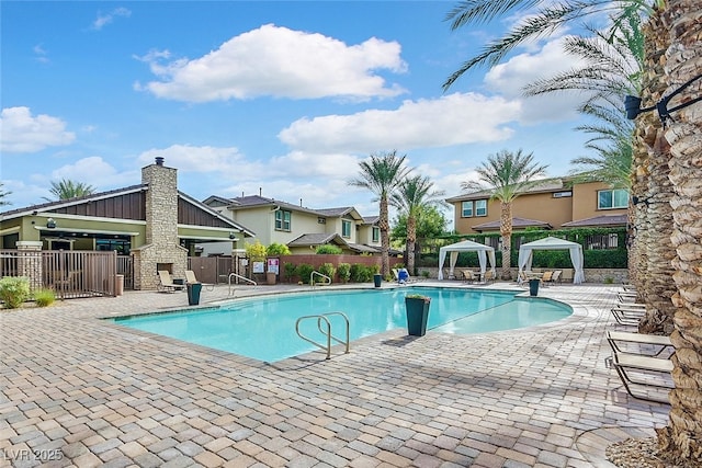 view of pool featuring an outdoor stone fireplace, a patio, and a gazebo