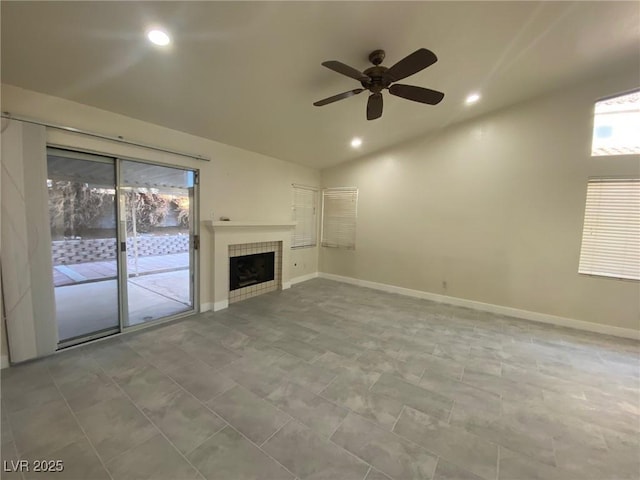 unfurnished living room with a tile fireplace, a wealth of natural light, ceiling fan, and lofted ceiling