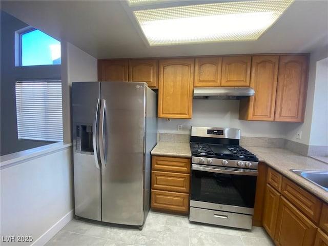 kitchen featuring appliances with stainless steel finishes, light tile patterned floors, and sink