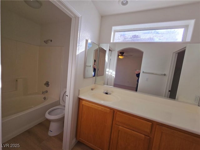 full bathroom featuring hardwood / wood-style floors, vanity,  shower combination, ceiling fan, and toilet