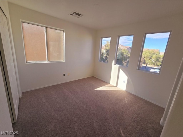 unfurnished room featuring dark colored carpet