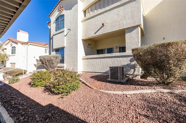 exterior space featuring central air condition unit and stucco siding