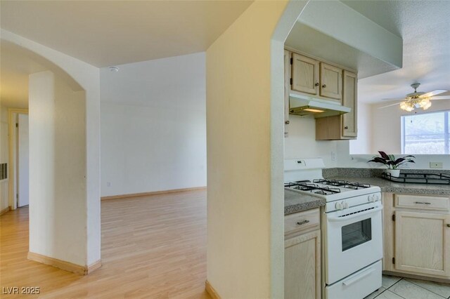 kitchen with white gas range, ceiling fan, and light wood-type flooring