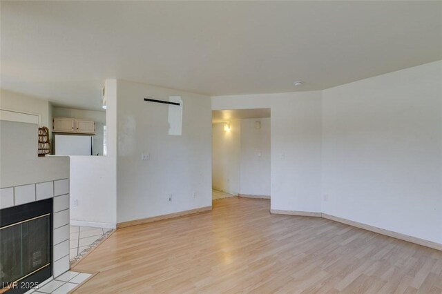 unfurnished living room with light wood-type flooring and a fireplace